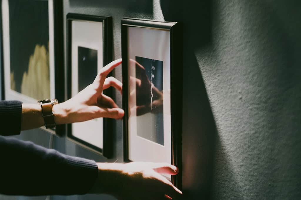Framed photographs being installed as part of an exhibition display.